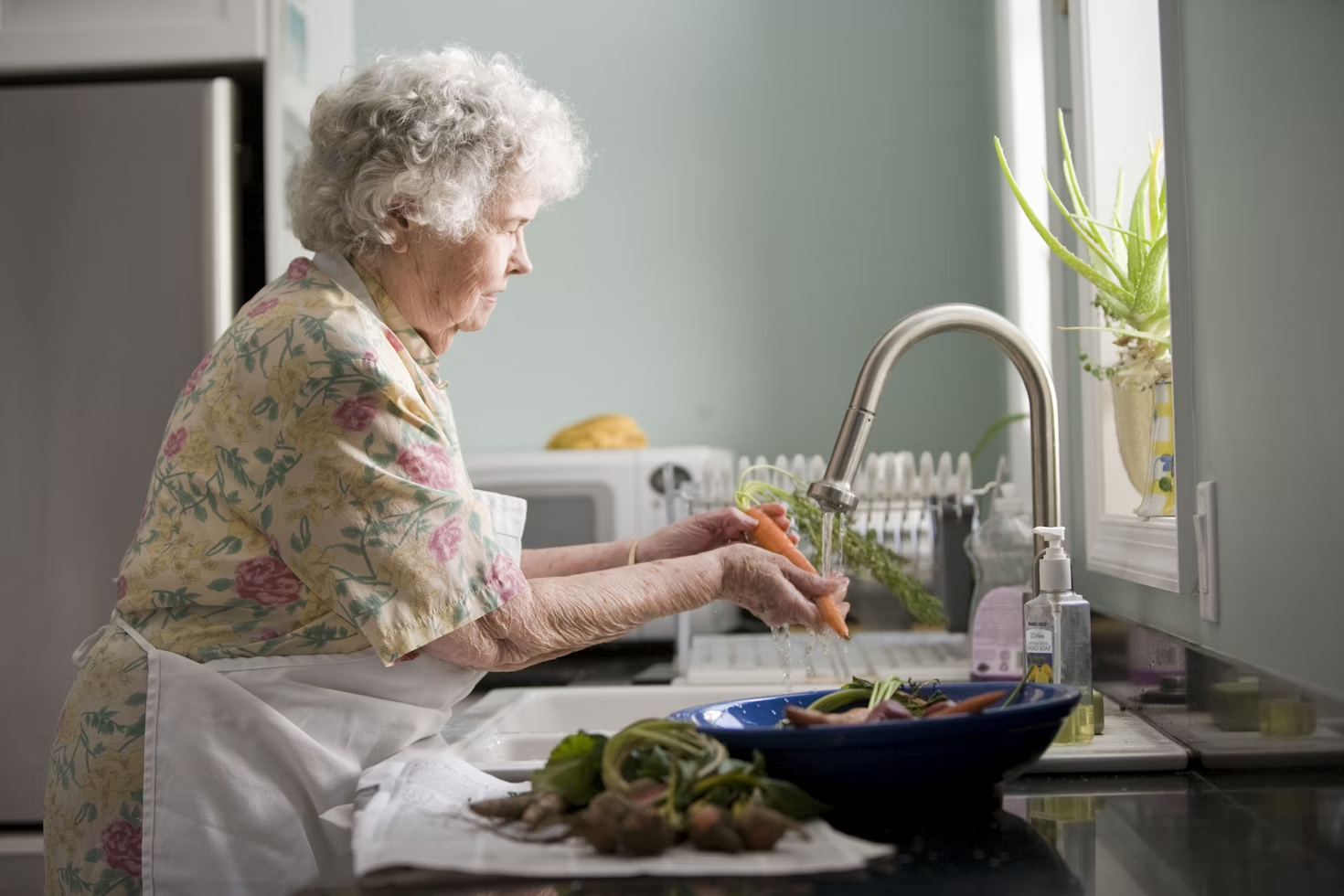 Senior woman washing veggies