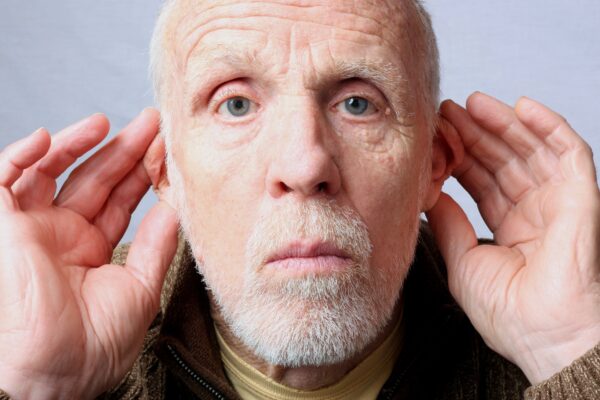 Hearing-impaired senior man ttyring to listen